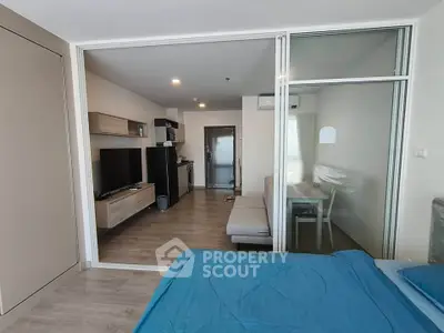 Modern studio apartment with open layout, featuring a cozy living area and sleek kitchen.