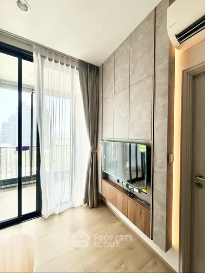 Modern living room with large windows and balcony view in a high-rise apartment.