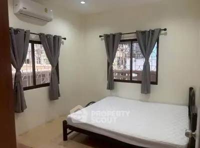 Cozy bedroom with natural light and air conditioning, perfect for relaxation.