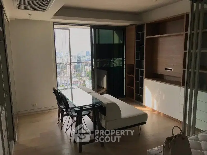 Modern living room with city view, featuring sleek furniture and ample natural light.