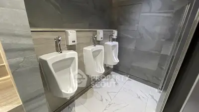Modern commercial bathroom with sleek urinals and stylish tile design.