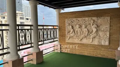 Charming balcony with artistic wall relief and city view, perfect for relaxation and enjoying the skyline.