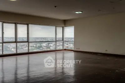 Spacious corner unit with panoramic city views and large windows, ideal for a modern living room setup.
