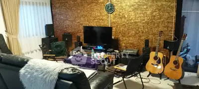 Cozy living room with musical instruments and sound system setup, perfect for music enthusiasts.