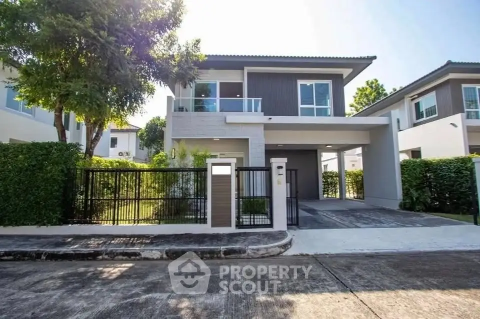 Modern two-story house with a spacious driveway and lush greenery in a serene neighborhood.