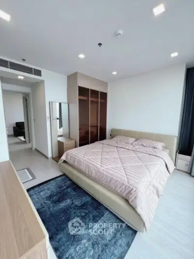 Modern bedroom with stylish decor and ample natural light in a contemporary apartment.