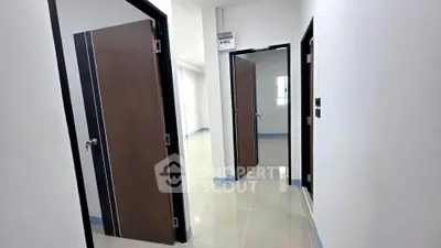 Spacious modern hallway with sleek doors and glossy tiled flooring