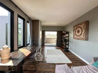 Spacious modern living room with elegant decor and large windows offering natural light.