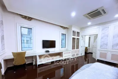Luxurious bedroom with elegant decor and modern amenities, featuring a wall-mounted TV and stylish furnishings.