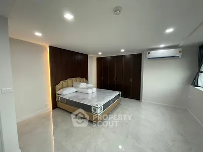 Spacious modern bedroom with sleek design and ample storage in luxury apartment.