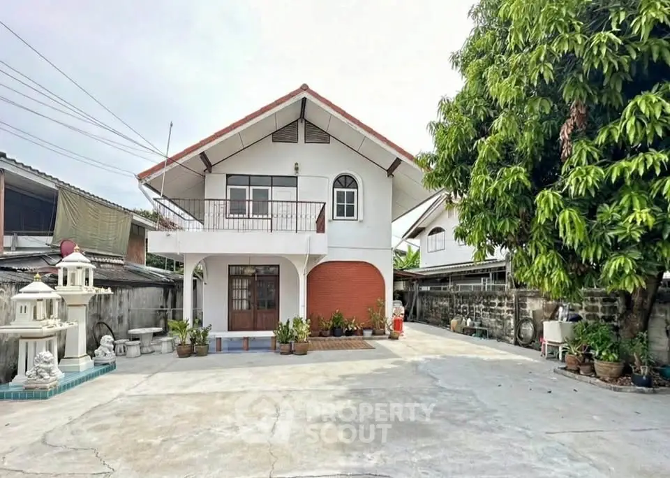 Charming two-story house with spacious driveway and lush greenery, perfect for family living.