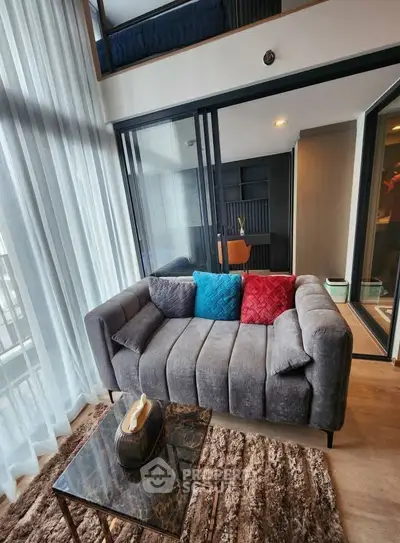 Modern living room with stylish sofa and floor-to-ceiling windows in a contemporary apartment.