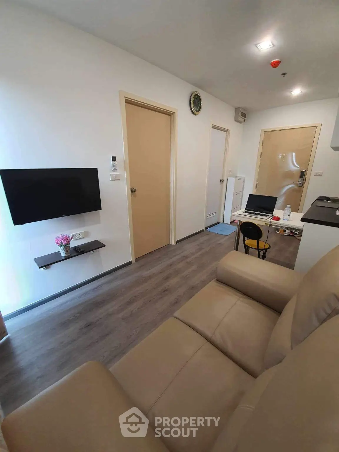 Modern living room with sleek design and wall-mounted TV in cozy apartment.