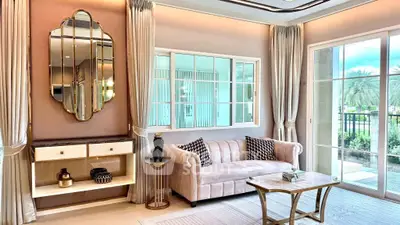 Elegant living room with plush sofa, stylish mirror, and large window overlooking garden.