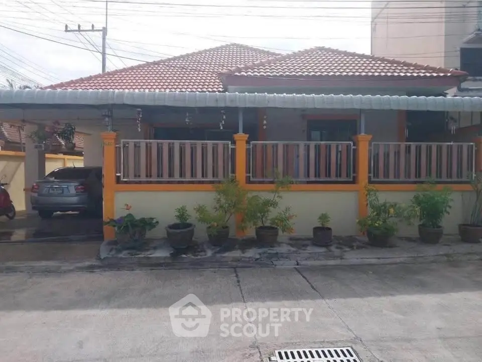 Charming single-story house with tiled roof and cozy front garden, perfect for family living.