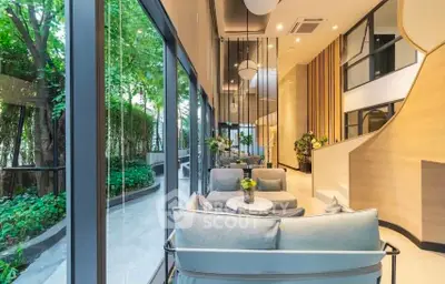 Luxurious modern living room with floor-to-ceiling windows and lush garden view.
