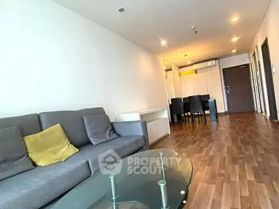 Spacious modern living room with wooden flooring and stylish furniture in a contemporary apartment.