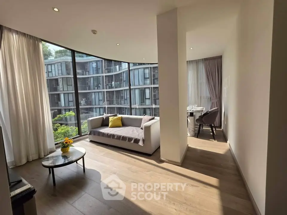 Modern living room with floor-to-ceiling windows and stylish furniture in a luxury apartment.