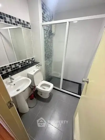 Modern bathroom with sleek shower and stylish black and white tiles