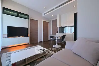 Modern living room with sleek furniture and open kitchen layout in a stylish apartment.