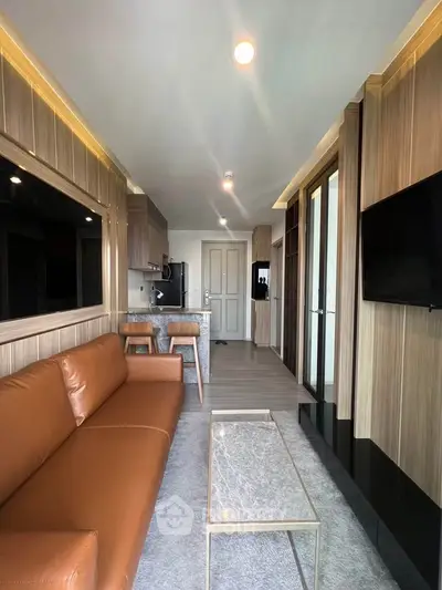 Modern living room with brown leather sofa and sleek kitchen area