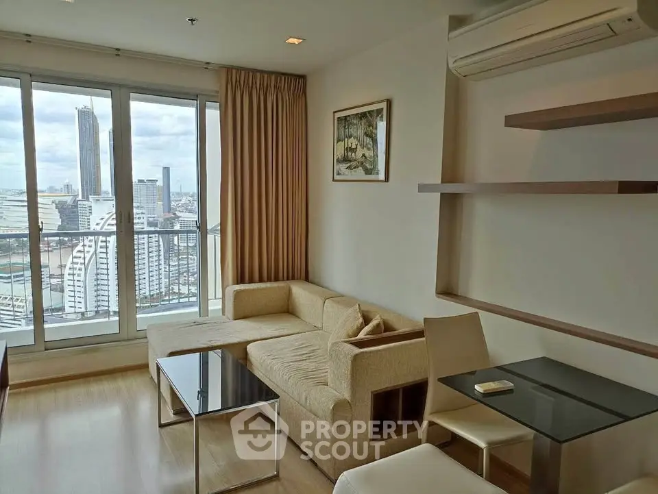 Modern living room with city view, featuring stylish furniture and large windows in a high-rise apartment.