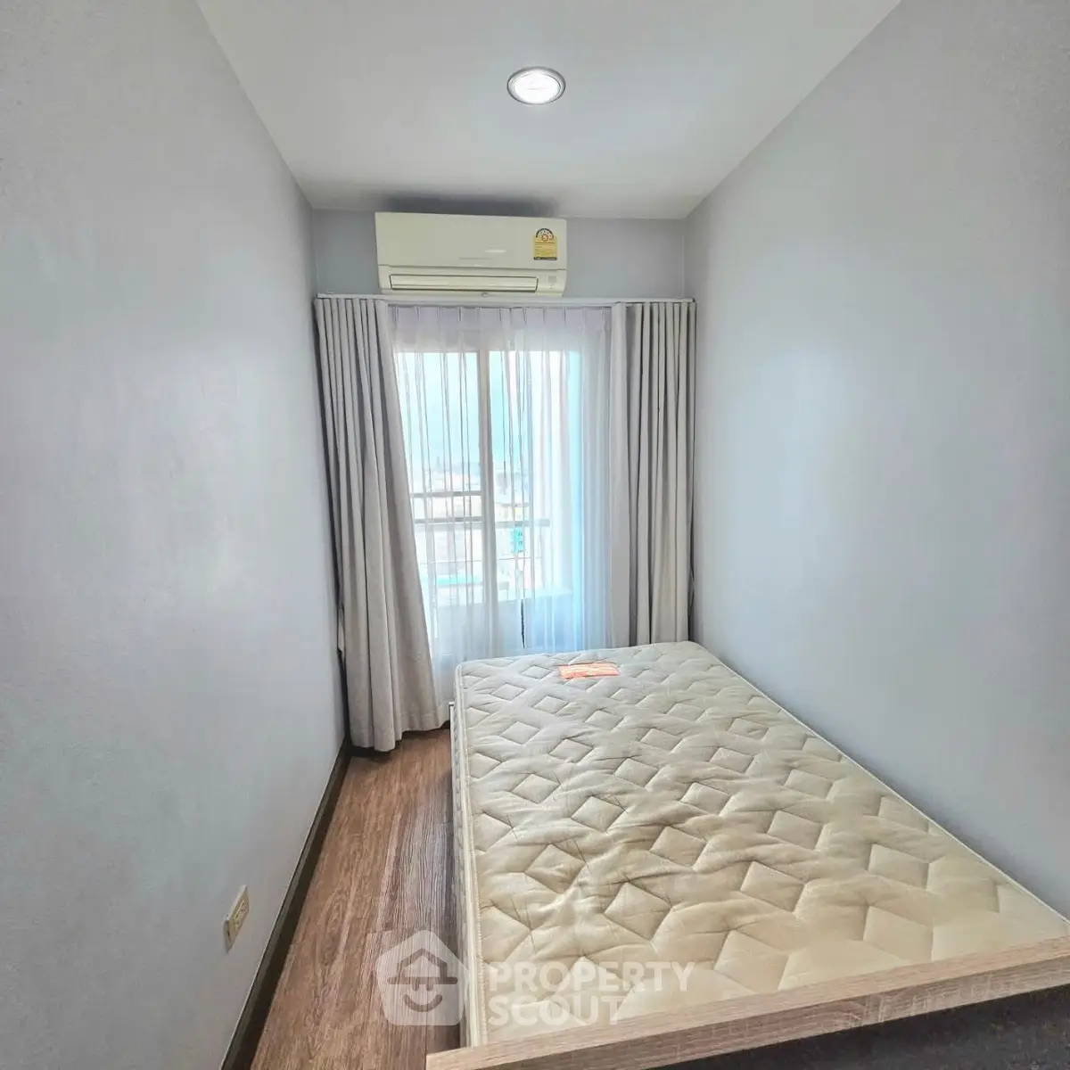 Cozy bedroom with natural light and air conditioning, perfect for a restful retreat.