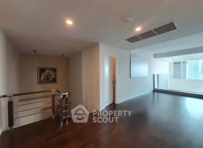 Spacious modern living room with wooden flooring and natural light