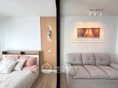 Modern studio apartment with cozy bed and stylish sofa, featuring elegant wall art and contemporary lighting.