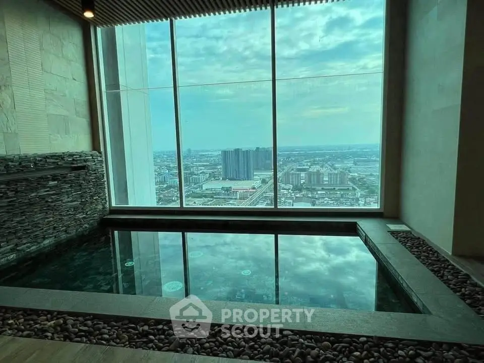 Luxurious indoor pool with stunning cityscape view from high-rise building.