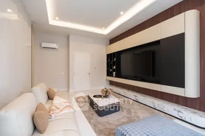 Luxurious modern living room with sleek entertainment center and cozy seating area.