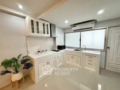 Modern kitchen with sleek white cabinetry and air conditioning unit, perfect for culinary enthusiasts.