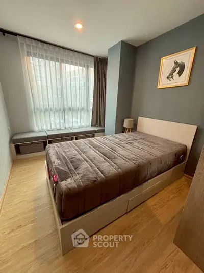 Cozy bedroom with modern decor and large window for natural light