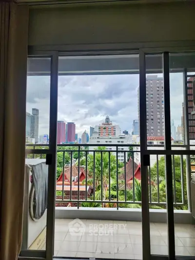 Stunning city view from modern balcony with lush greenery and urban skyline.