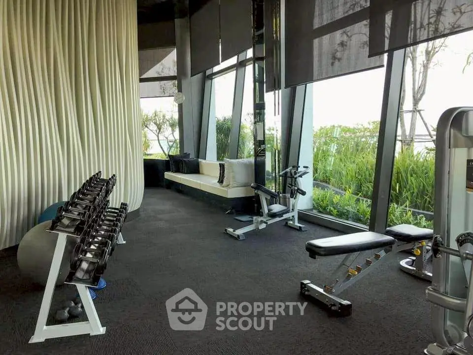 Luxurious gym with modern equipment and garden view in upscale residential building.