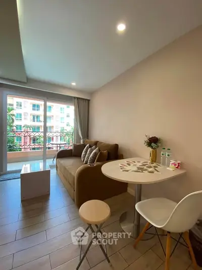 Cozy living room with modern decor and balcony view, perfect for relaxation.