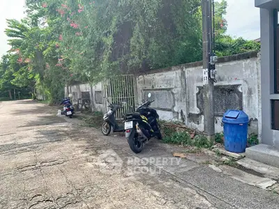 Charming street view with lush greenery and parked scooters, ideal for serene urban living.