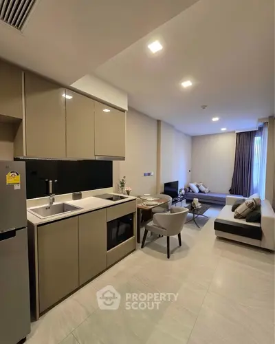 Modern open-layout kitchen and living room with sleek design and cozy seating area.