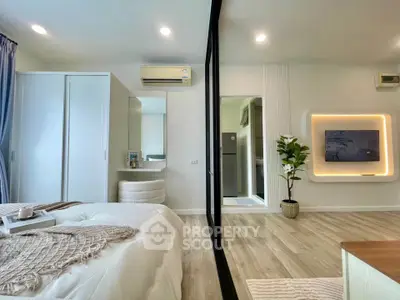 Modern bedroom with stylish decor and open layout, featuring a cozy bed, sleek wardrobe, and elegant lighting.