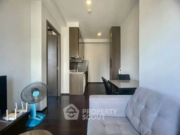 Modern apartment living room with cozy sofa and compact kitchen area