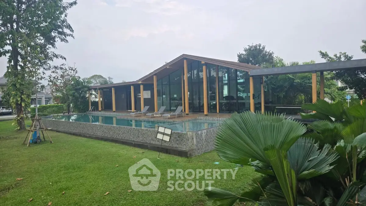Modern luxury home with sleek glass facade and inviting pool in lush garden setting.