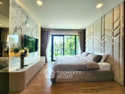 Luxurious bedroom with modern decor and large window offering scenic views.