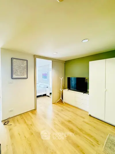 Modern living room with wooden flooring and sleek furniture in a bright apartment.