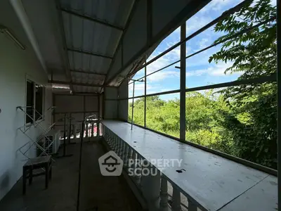 Spacious balcony with lush greenery view, perfect for relaxation and enjoying nature.