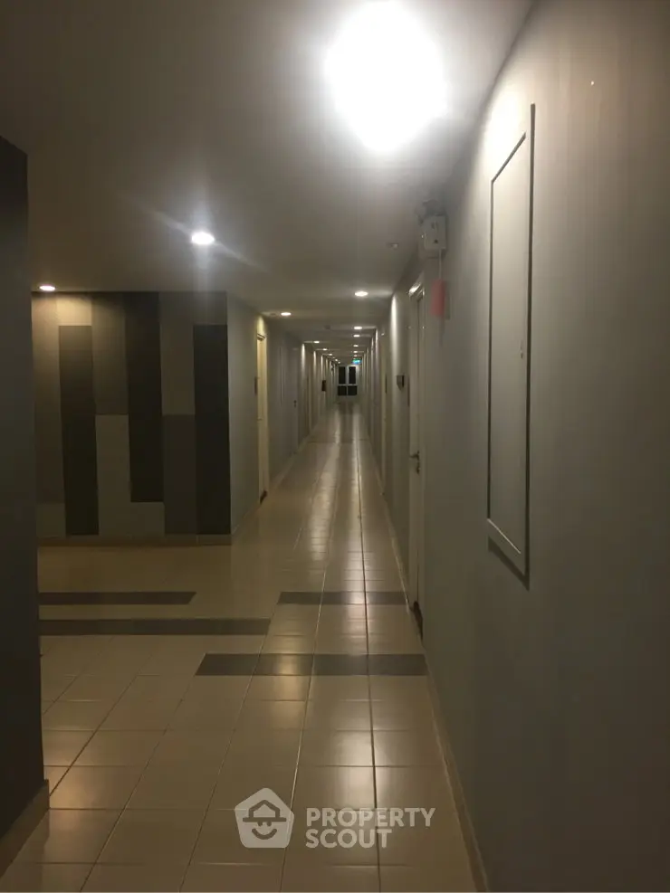 Modern apartment corridor with sleek lighting and tiled flooring.
