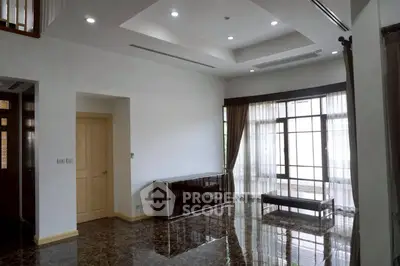 Spacious modern living room with marble flooring and large windows.