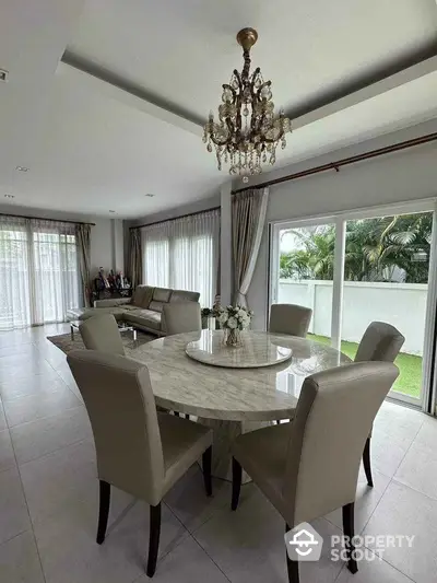 Elegant dining area with chandelier and garden view in modern home