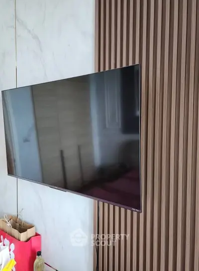 Modern living room with sleek wall-mounted TV and stylish paneling