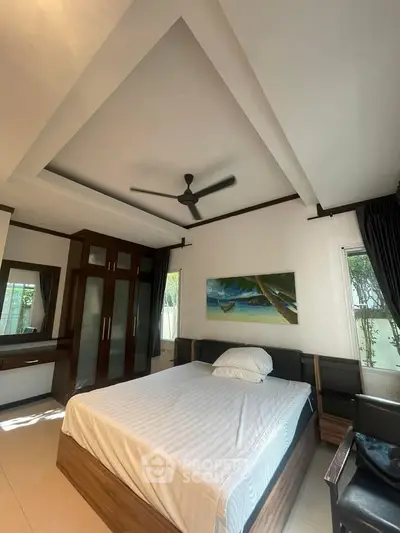 Spacious bedroom with modern ceiling fan, large wardrobe, and elegant decor in a bright, airy setting.