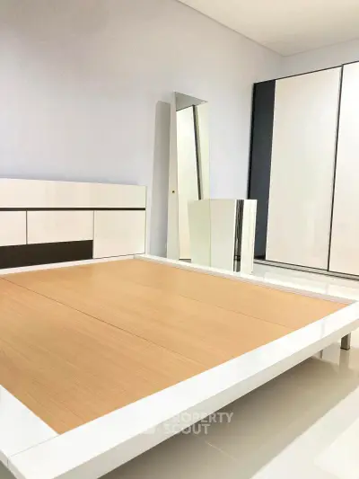 Modern minimalist bedroom with sleek furniture and ample storage space.